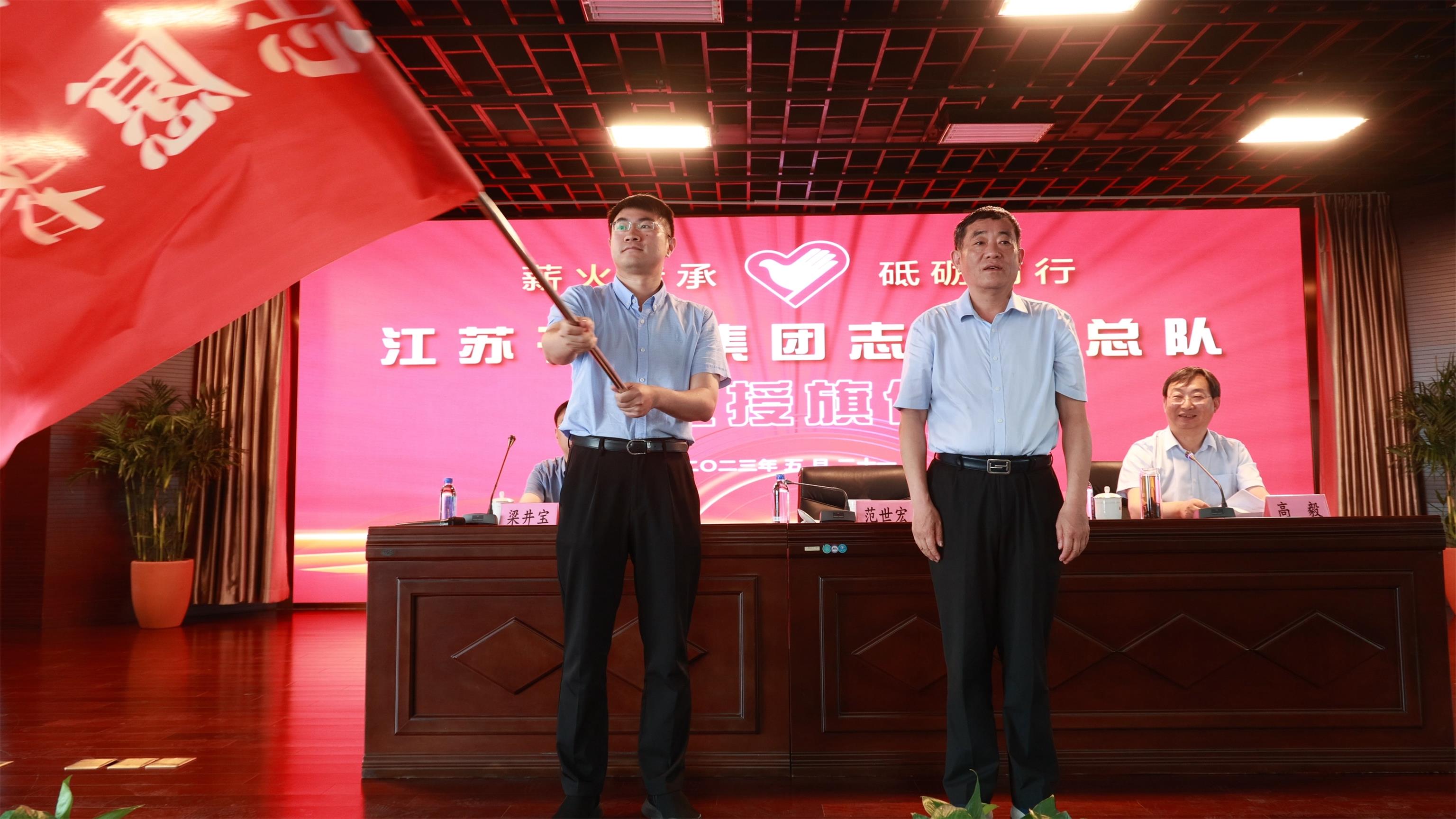 图1-3、范世宏董事长为邗建志愿者总队授旗.jpg